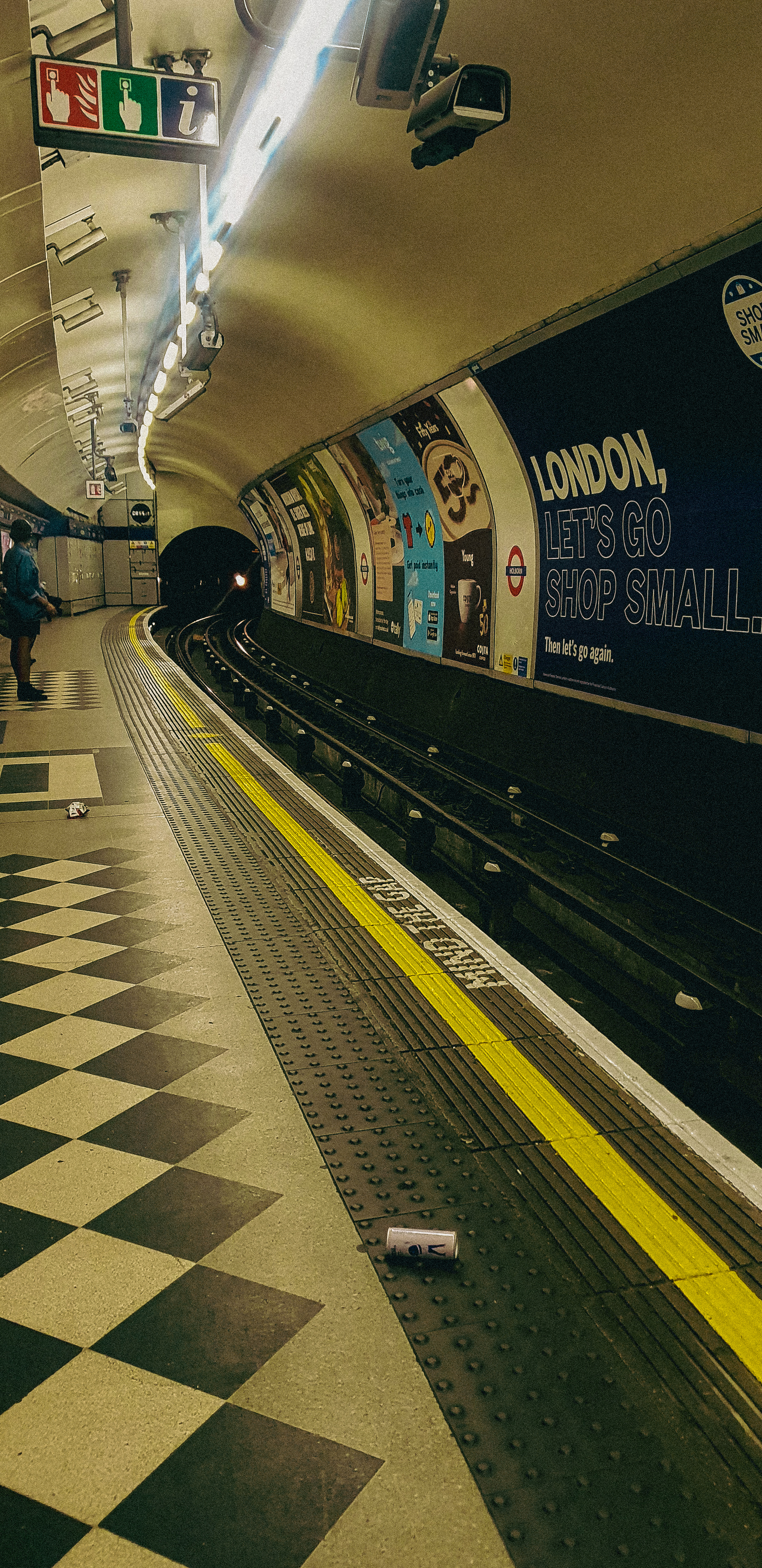 Image of  black woman at empty tube platform at Holborn Tube Station, London, UK